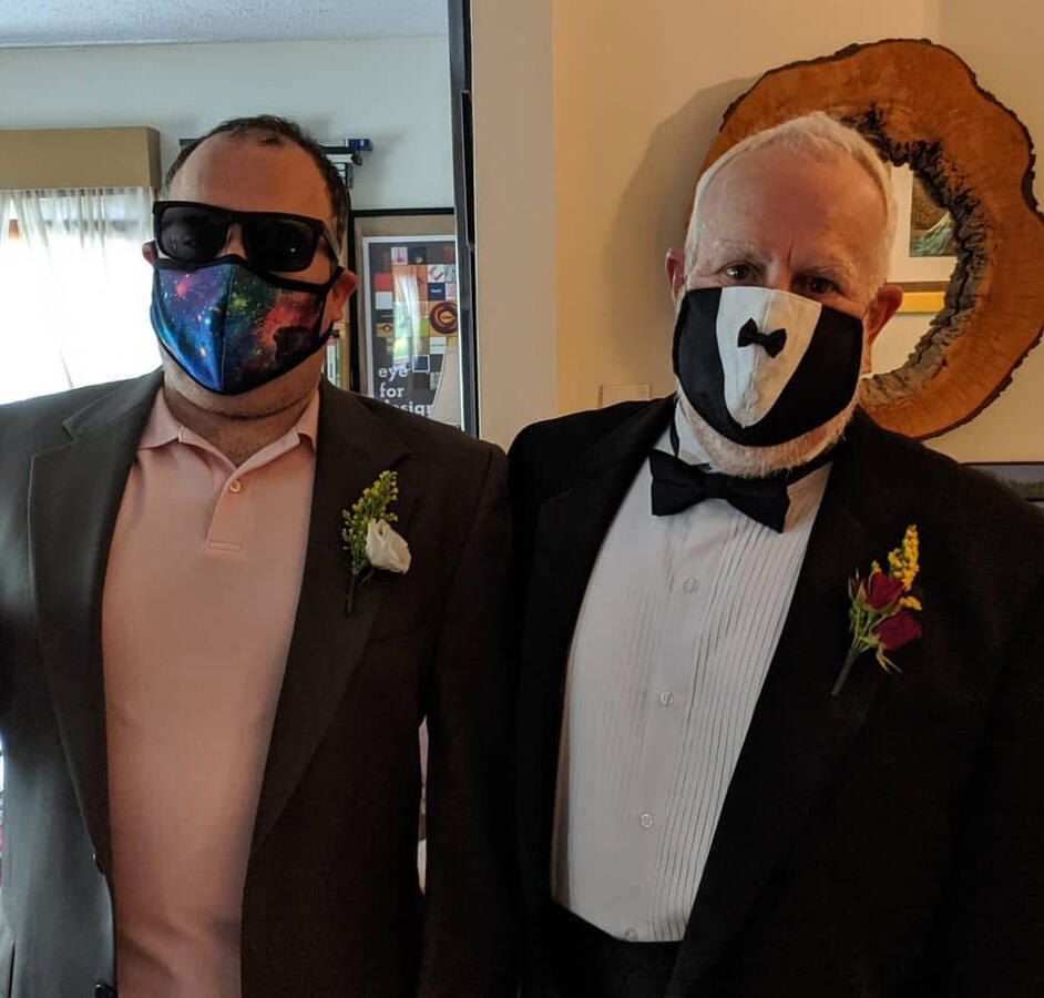 Two men in suits wearing rose boutineers.